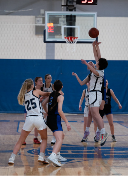 Senior Sasha Makogonov, taking the jump ball, while teammates are ready to grab it.